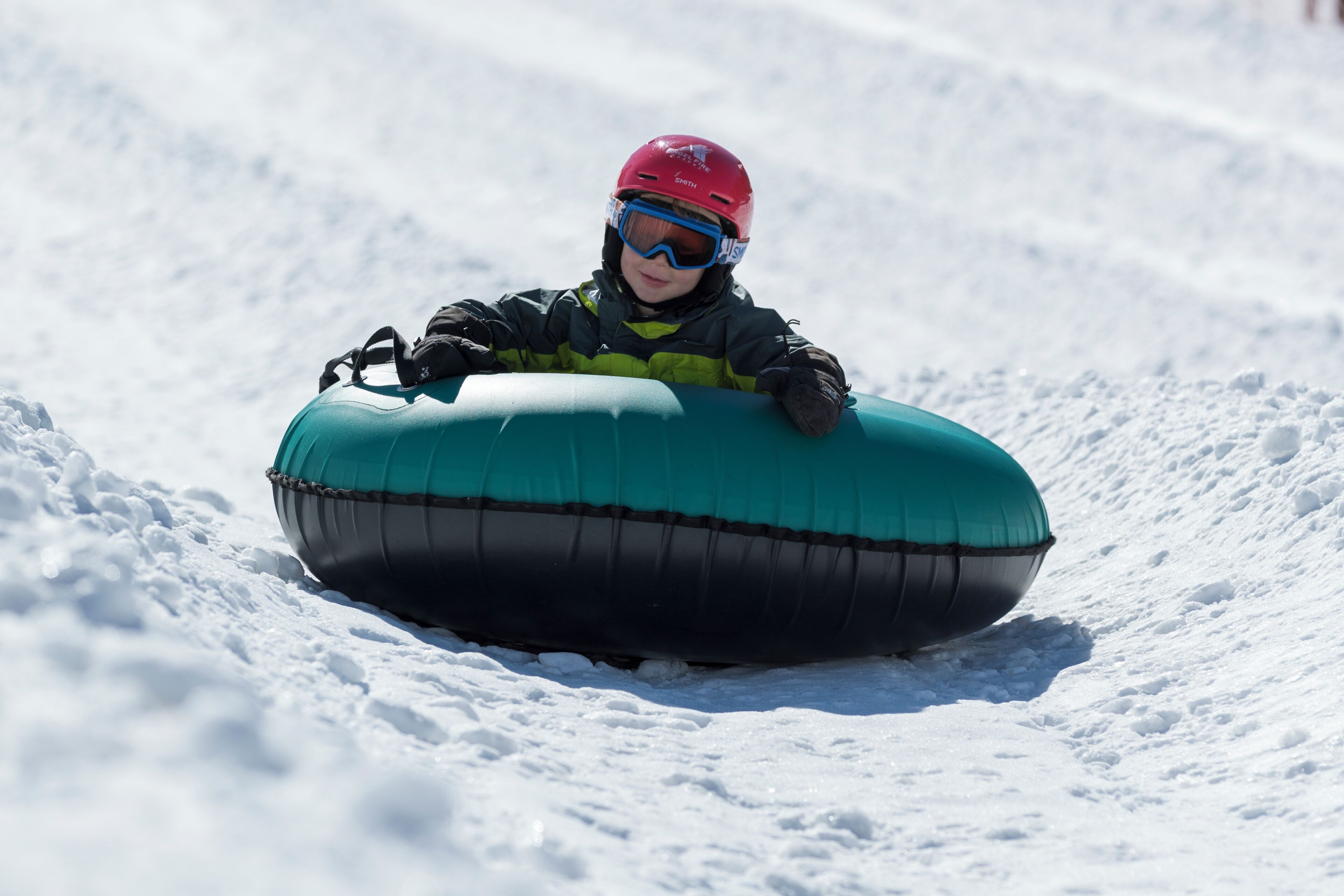 Un enfant sur une bouée à neige.