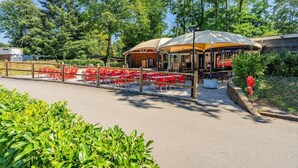 An outdoor seating area with red tables and chairs, a covered pavilion, and a fire hydrant. - RELAXING MOBILE HOME AND FRIENDLY POOL (Saint-Chéron)