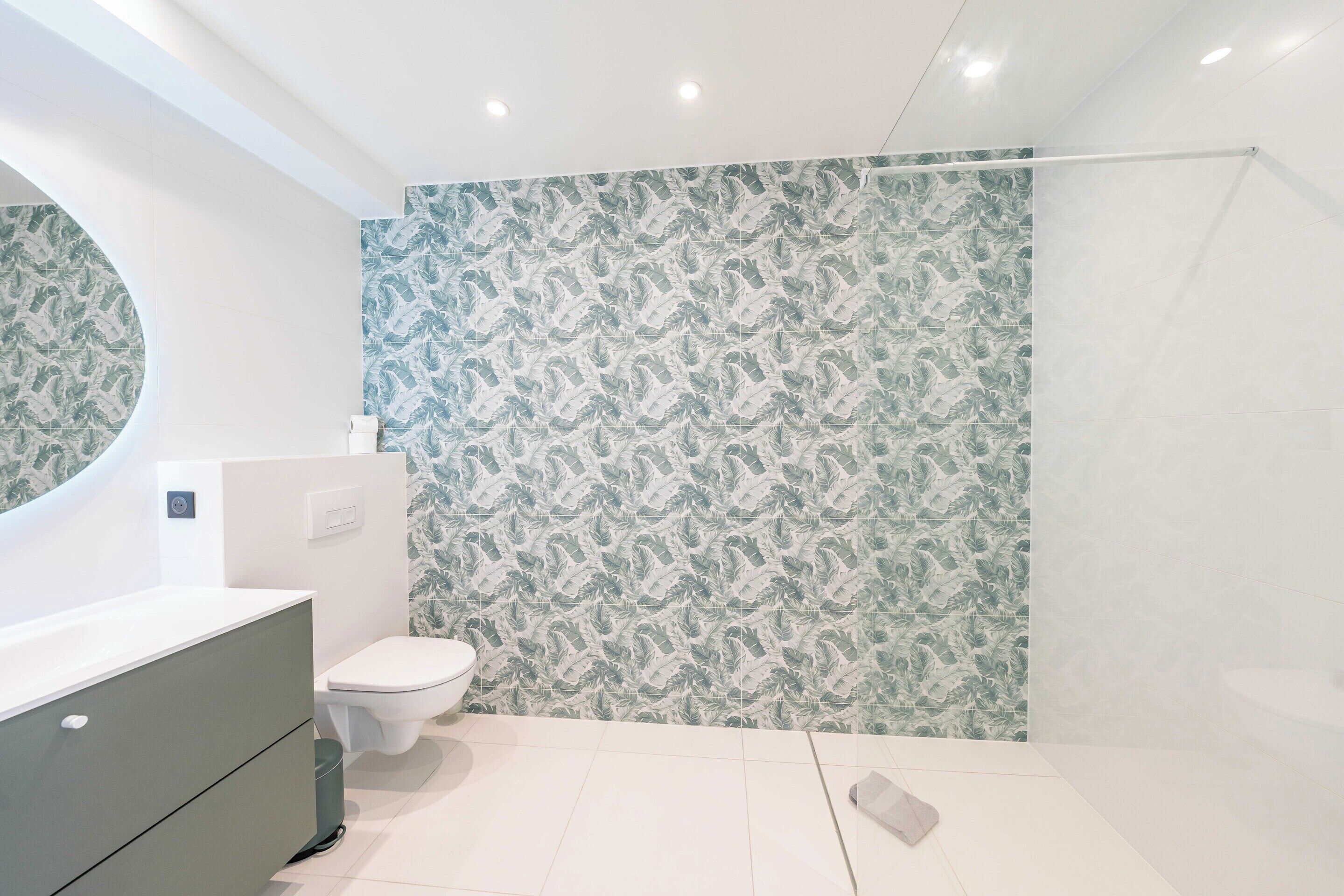 Une salle de bain moderne équipée de toilettes, d’un lavabo et d’un espace douche.