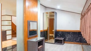 A hotel room with a wooden panel wall, a marble accent wall, a mirror, a vanity, and a staircase. - Hi Quality Dago by My Hospitality (Coblong)
