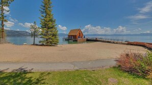Une plage avec une structure en bois, un ciel dégagé et un lac paisible.