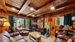 L’intérieur chaleureux d’un chalet avec un canapé en cuir, une table basse en bois et une cheminée.