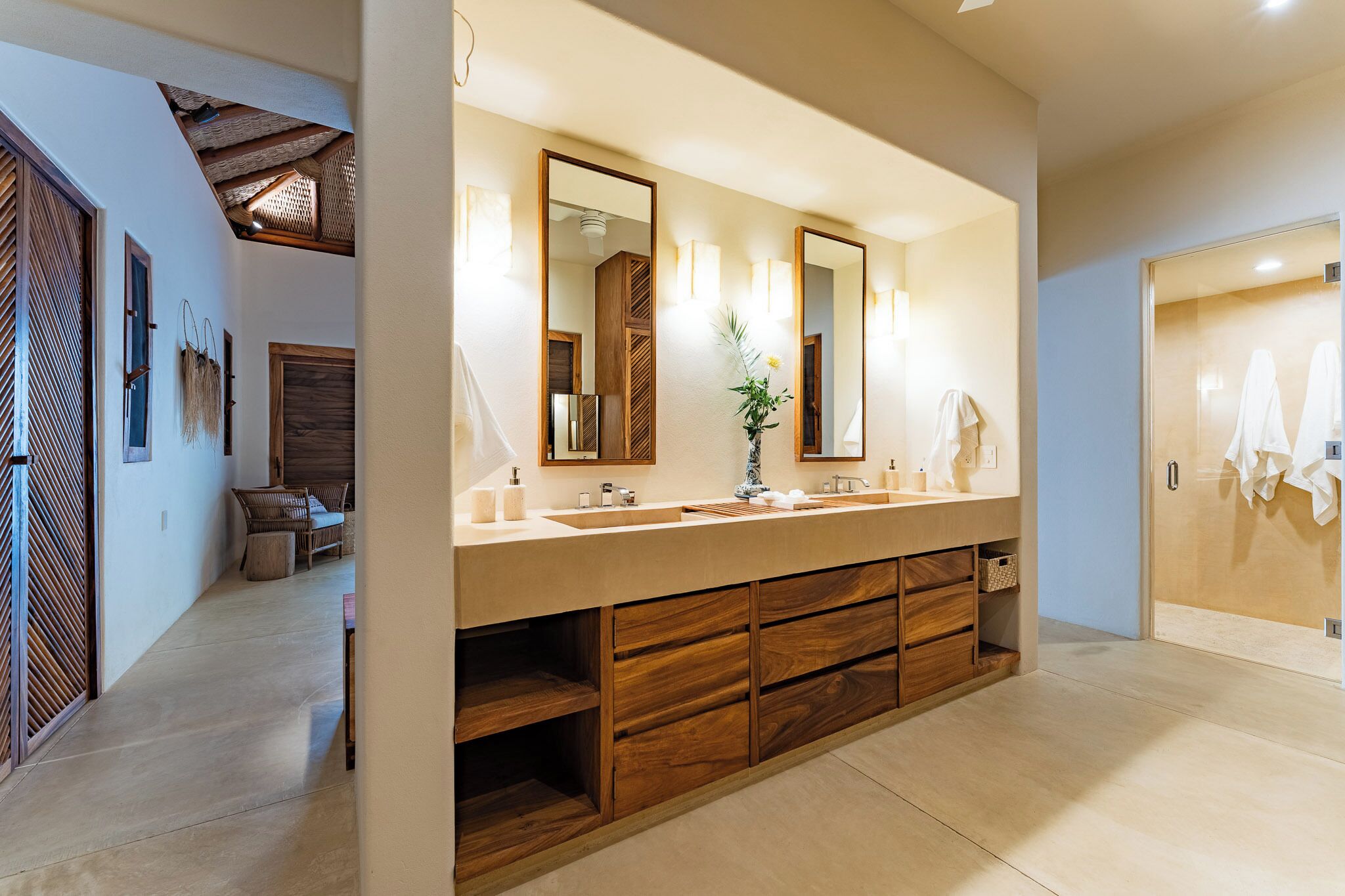 Un baño moderno con un tocador amplio, armarios de madera y un espejo.