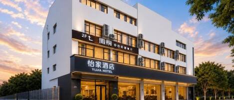 A modern hotel building with a prominent entrance and signage.