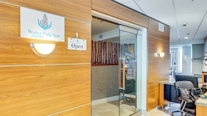 A reception area with a wooden wall, a glass door, and a sign indicating the spa is open. - Community Perks: Scenic Lake Travis Getaway! (Lago Vista)