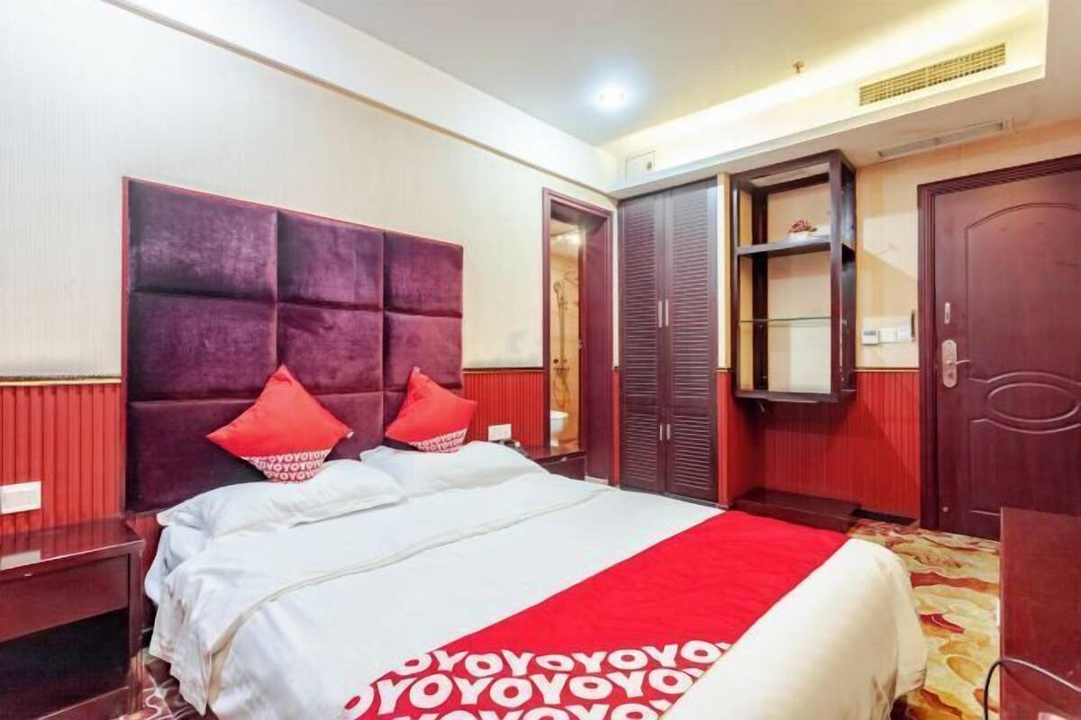 Een hotelkamer met een groot bed, een kledingkast en een spiegel.