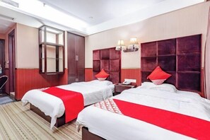 Een hotelkamer met twee bedden, een grote spiegel en een rode accentmuur.