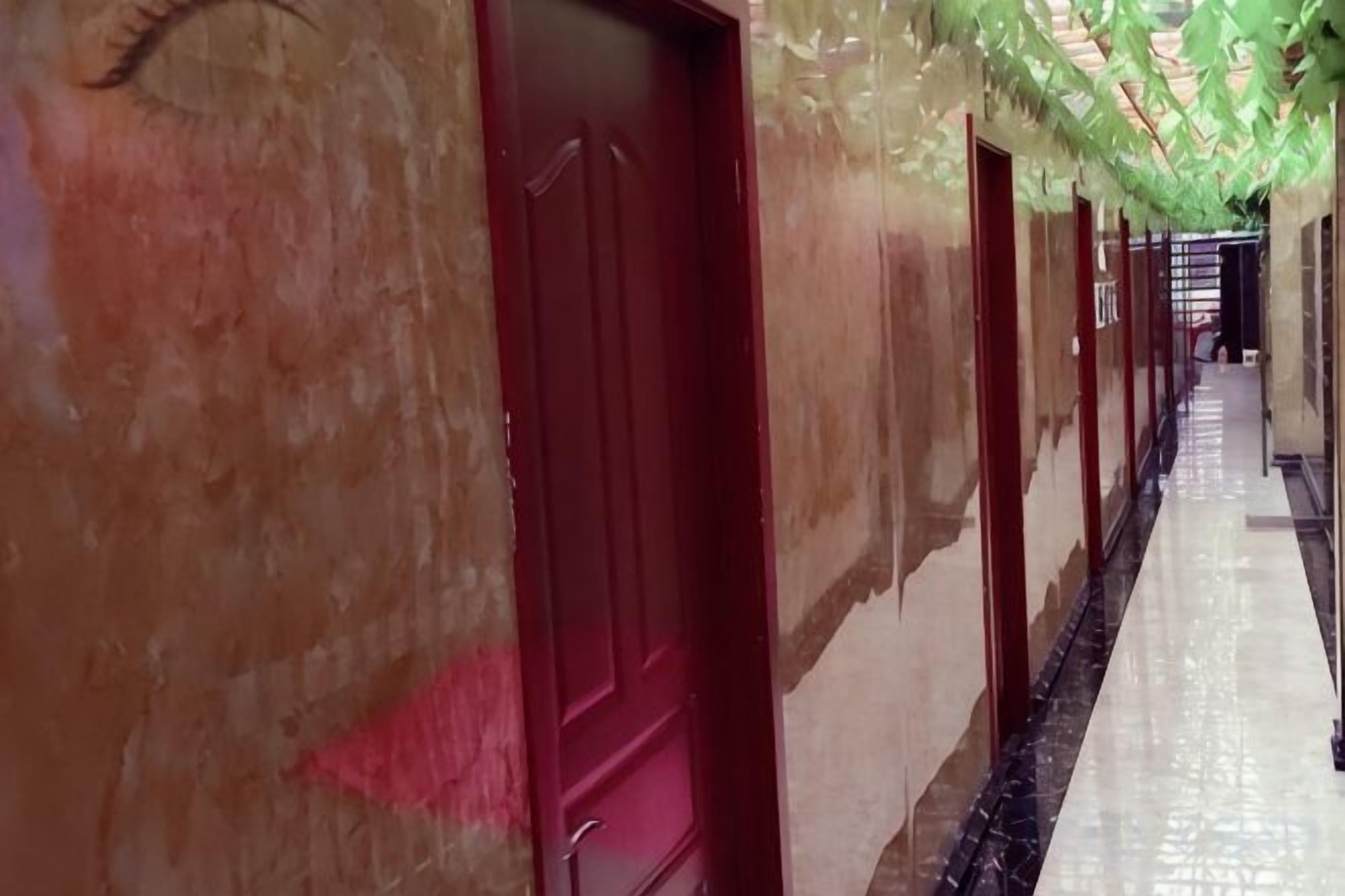 A hallway with doors, a tiled floor, and a green decorative element.