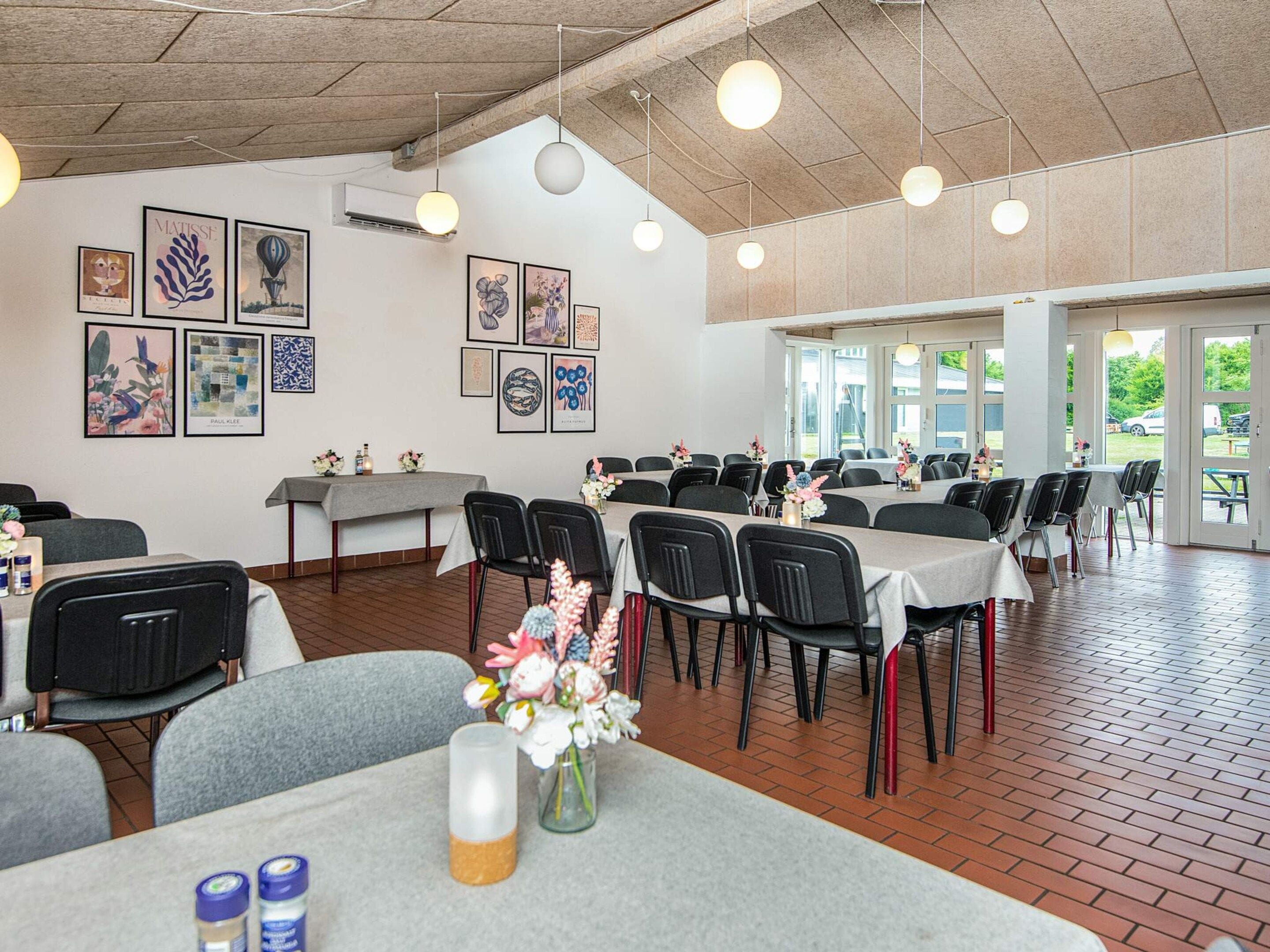 A dining area with tables, chairs, and artwork on the walls.