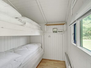 A bunk bed room with white bedding, a small window, and a thermostat on the wall. - 4 Person Holiday Home in Hampen (Hampen)