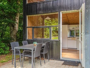 Een rustiek houten gebouw met een eethoek, inclusief een tafel en stoelen.
