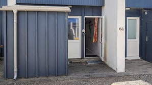 A building with a grey exterior, a door with a number '63' on it, and a small entrance area with a mat. - 4 Person Holiday Home in Vestervig (Vestervig)