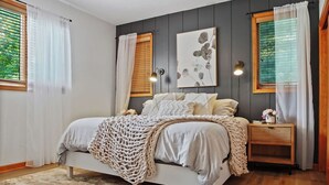 A bedroom with a bed, a ceiling fan, a bedside table, and a window with curtains. - Ultimate Group Stay, Pickelball, H/Tub, Fire Pit (Lake Harmony)