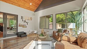 A spacious living room with a wooden ceiling, large windows, and a cozy seating area. - Ultimate Group Stay, Pickelball, H/Tub, Fire Pit (Lake Harmony)