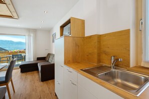 Una cocina moderna con una pared de acento de madera, un lavamanos empotrado y un comedor con vistas.