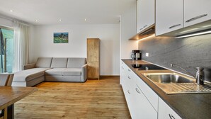 Eine moderne Küche mit Spüle, einem Holztisch und einem grauen Sofa.