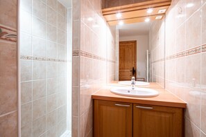 A bathroom with a wooden vanity, two sinks, and a mirror.