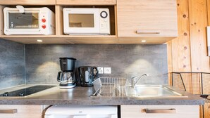 Een keuken met een magnetron, broodrooster, koffiezetapparaat en vaatwasser.