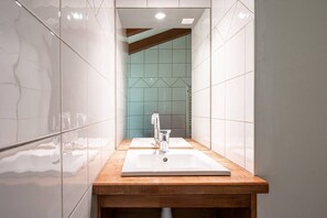 A bathroom with two sinks, a wooden countertop, and a mirror.