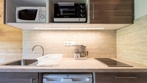 A modern kitchen with a microwave, toaster, coffee maker, and dishwasher.