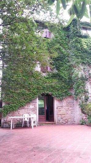 A stone building with a covered patio, a table, and chairs. - Holiday Home 'Nel Cilento' with Mountain View, Private Terrace and Garden (Gioi)
