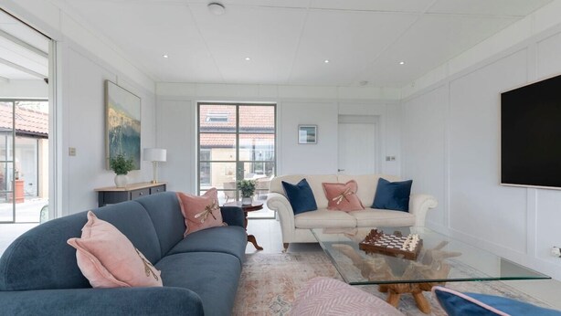A modern living room with a sofa, a coffee table, and a TV.