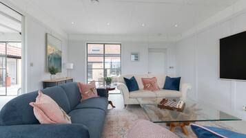 A modern living room with a sofa, a coffee table, and a TV.