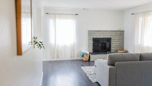 A living room with a fireplace, a sofa, and a rug. - Soothing 2-bedroom house with WiFi in Vista (Vista)