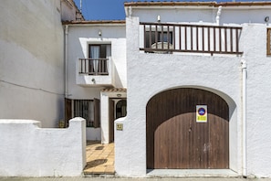 Un edificio blanco con puerta de madera y un balcón.