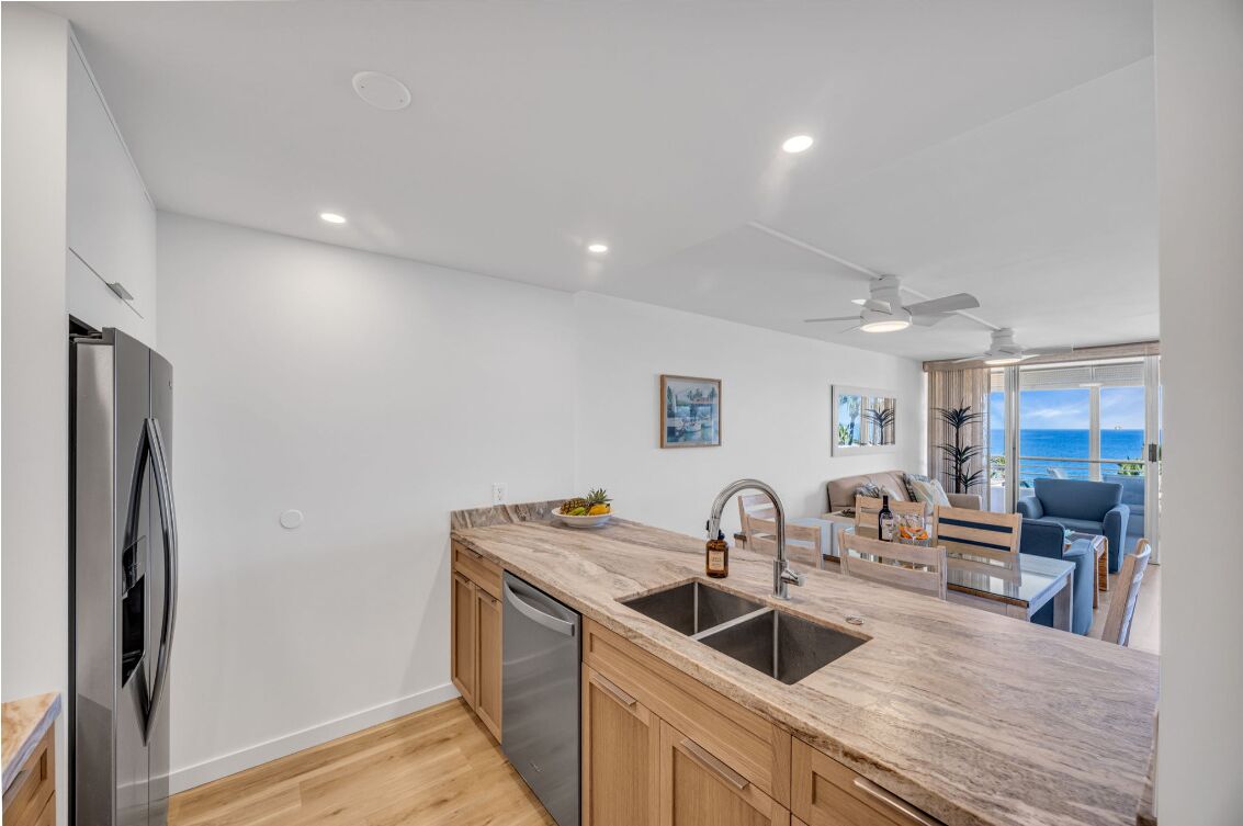 A modern kitchen with a marble countertop, stainless steel appliances, and a built-in dishwasher.