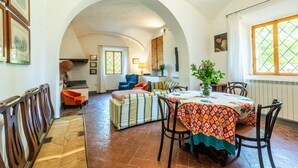 An interior with a dining area, a sofa, and a bench. - Villa 'Ballati' with Shared Garden (Ville di Corsano)