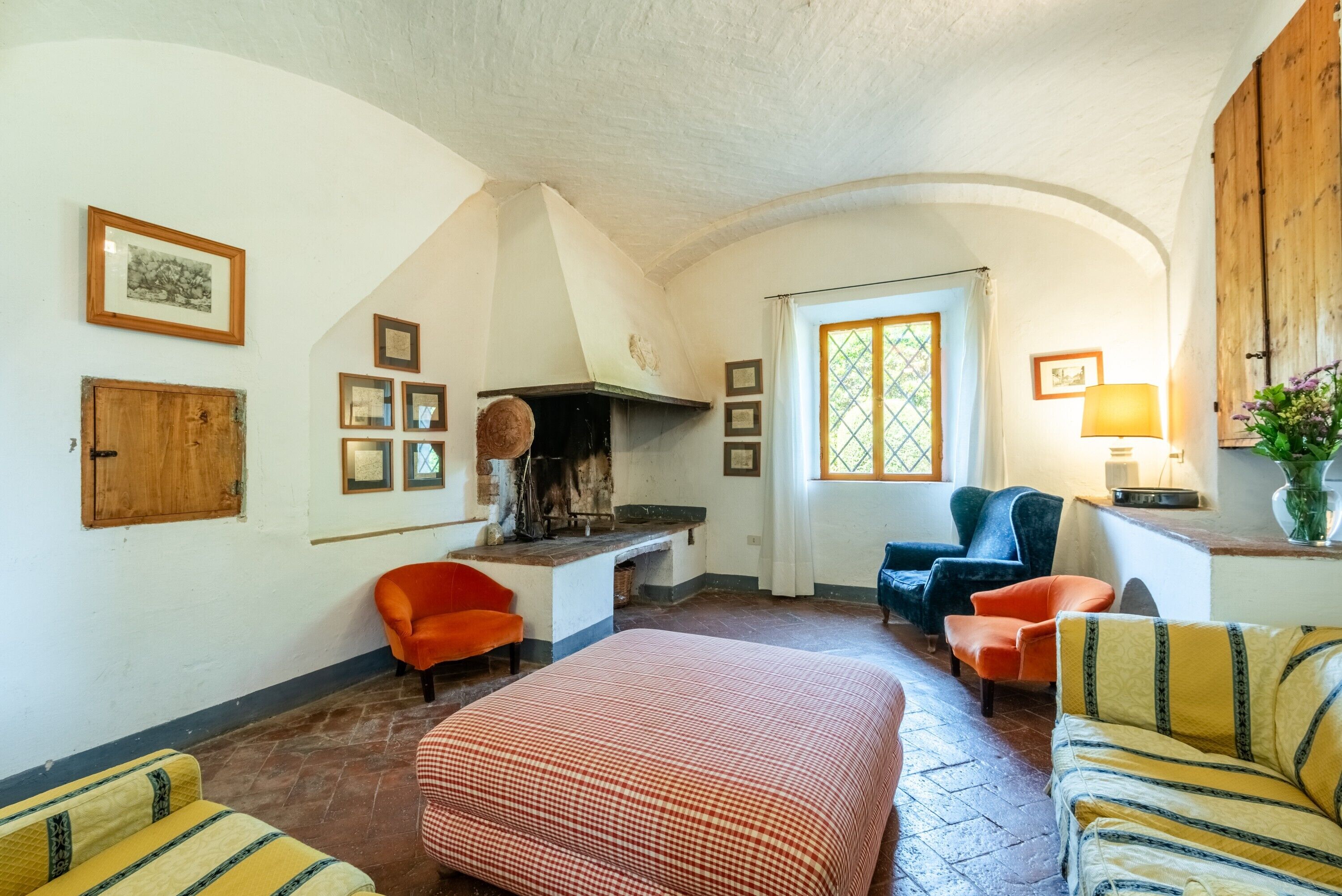 A cozy room with a fireplace, a bed, and two sofas.