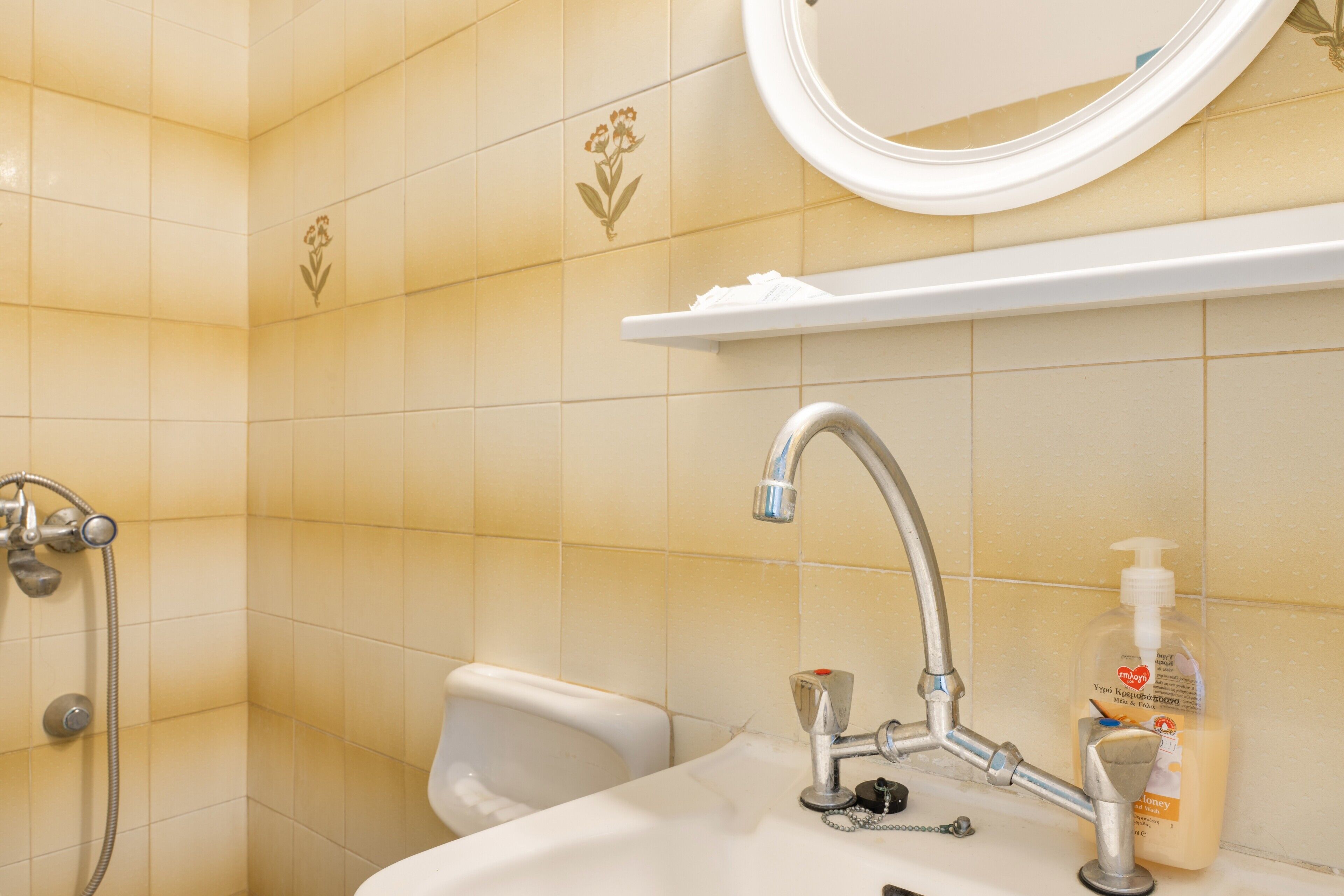 Ein Badezimmer mit Waschbecken, Spiegel und Dusche.