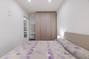 A bedroom with a bed, a wardrobe, and a radiator.