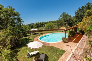 Un jardin avec une piscine, des chaises longues et une pergola.