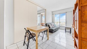 Amplia sala de estar con mesa de comedor, sillas, sofá y un mueble de madera.