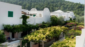 A white building with arched windows and a balcony with greenery. - Apartment 'Maritalia 3' with Private Terrace, Private Garden and Air Conditioning (Valle Clavia)