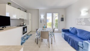 Een modern appartement met keuken, eethoek en woonkamer.