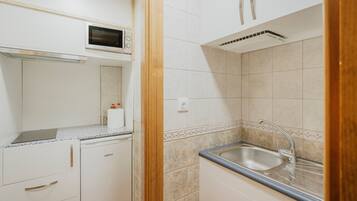 Een koelkast, een magnetron, een kookplaat, een broodrooster