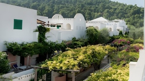 Un edificio blanco con ventanas arqueadas y un balcón con plantas.