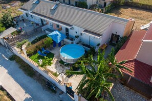 A residential property with a swimming pool, a covered patio, and a fenced yard. - Room 'Relaxroom 2' with Shared Garden, Wi-Fi and Air Conditioning (Lefkimmi)