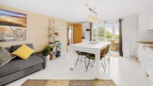 A modern living room with a sofa, a dining table, and a kitchen area. - Holiday Home 'Serena Vista' with Mountain View, Wi-Fi, and Air Conditioning (Alcaucín)