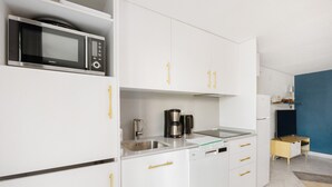 A modern kitchen with white cabinets, a microwave, a coffee maker, and a dishwasher. - Holiday Home 'Serena Vista' with Mountain View, Wi-Fi, and Air Conditioning (Alcaucín)