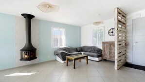 A room with a fireplace, a sofa, a coffee table, and a door with a wooden slat design.
