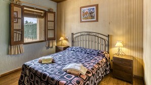 A bedroom with a bed, two bedside tables with lamps, a window with curtains, and a wall-mounted picture. - Apartment 'Cal Ferrer 2 - Quadres' with Shared Pool, Wi-Fi and Air Conditioning (Unknown)