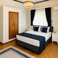 Habitación de hotel con una cama grande, un armario de madera, una mesita de noche y un candelabro.