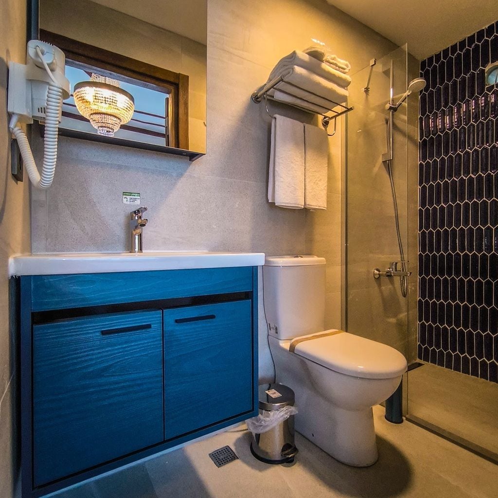 A bathroom with a toilet, sink, and shower.