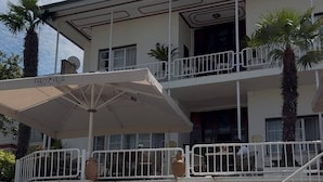 A two-story building with a balcony, a palm tree, and a sign that reads 'PALM VILLA.' - Palm Villa  (Adalar)
