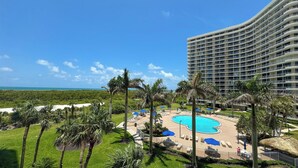 A resort with a large pool, palm trees, and a view of the ocean. - South Seas Tower 3-401: Marco Island Rental Properties (Marco Island)