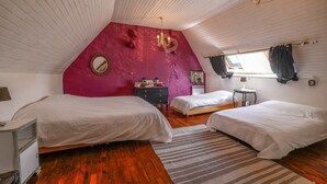 Un dormitorio con dos camas, un aparador, un tocador y una araña.